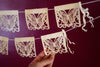 Corn husk papel picado by Ay Mujer. Mariposa design  cut into hojas de maiz and strung into banner art.