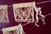 Corn husk papel picado by Ay Mujer. Mariposa design  cut into hojas de maiz and strung into banner art.